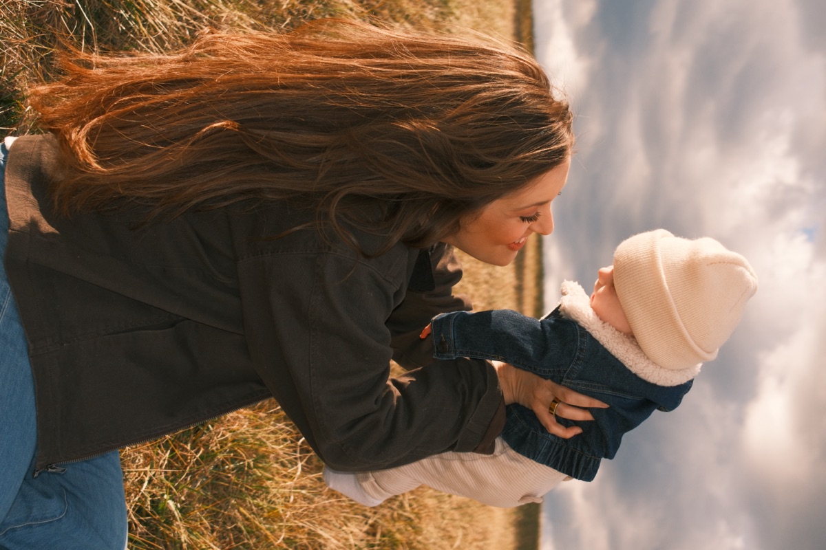 Lindsey Sawyer, UGC content creator, holding her baby in a field